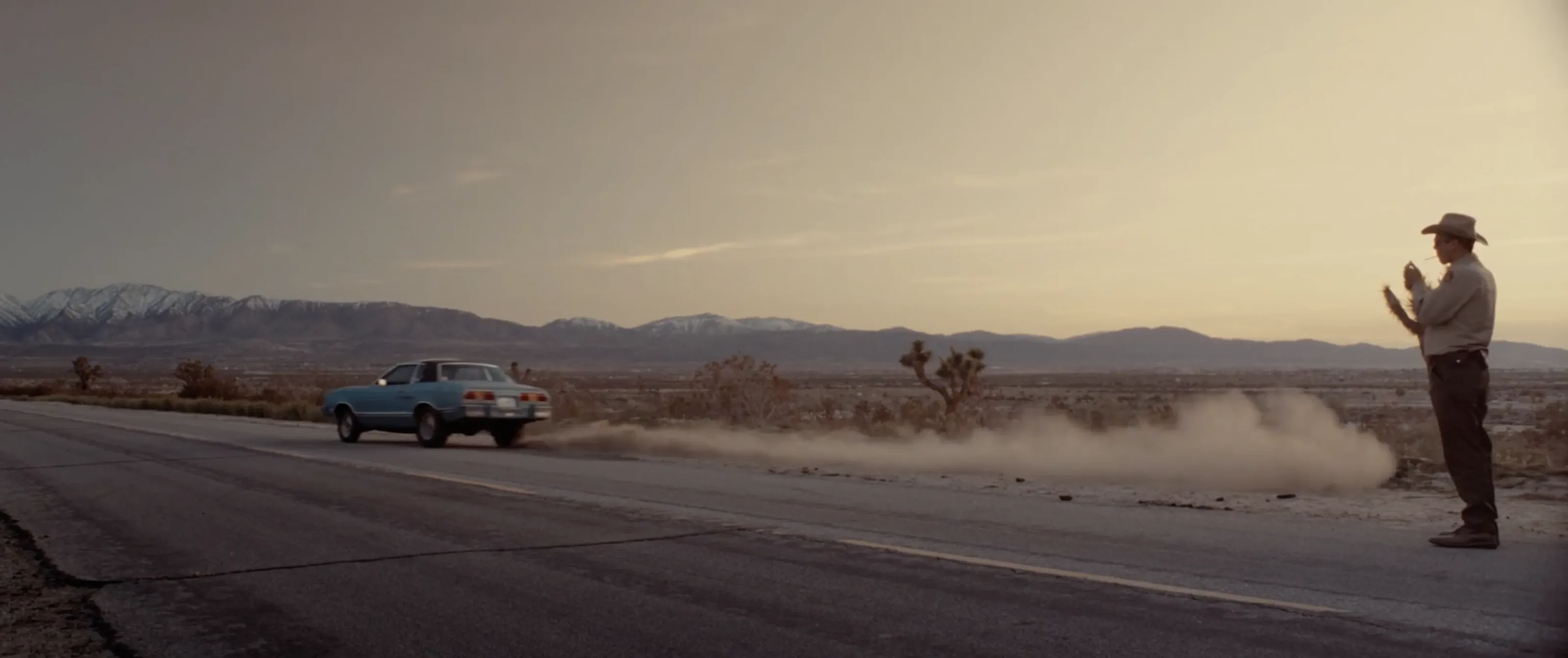 Sheriff Bilstein on a desert highway as Bobbi's car pulls away in Blood Star