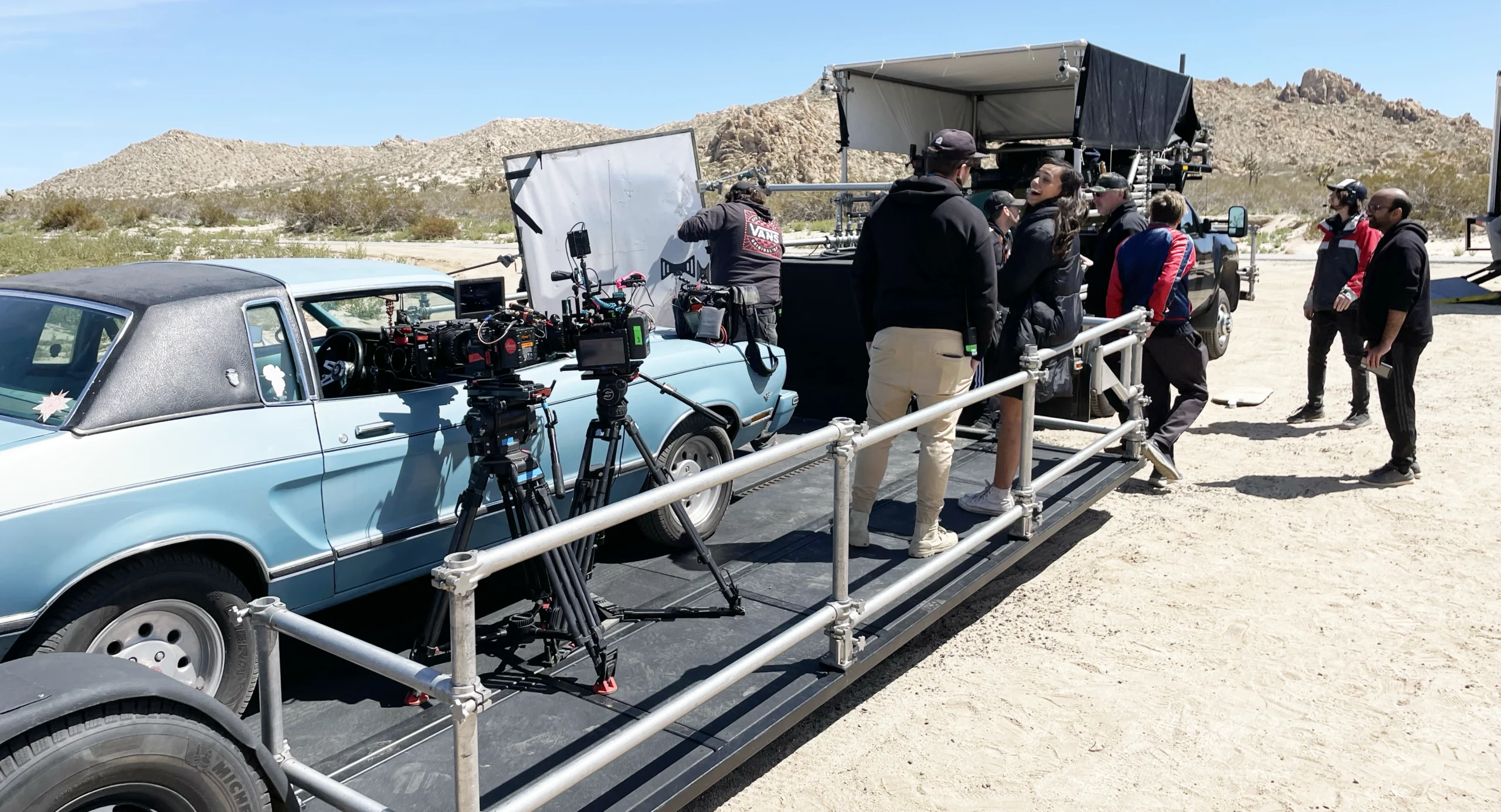 The picture car on a process trailer among rock formations in the Mojave Desert
