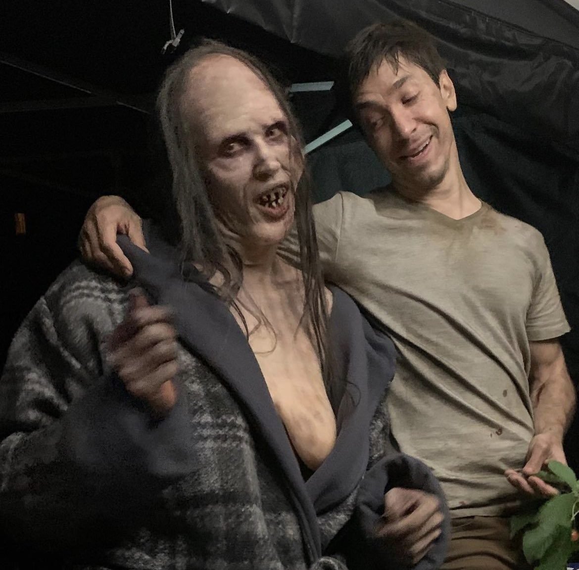 Behind-the-scenes photo of the actor posing in the Mother creature's costume alongside a cast member