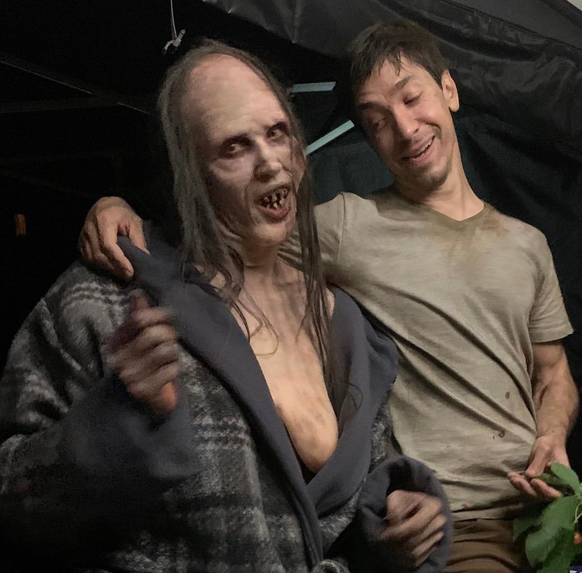 Behind-the-scenes photo of the actor posing in the Mother creature's costume alongside a cast member