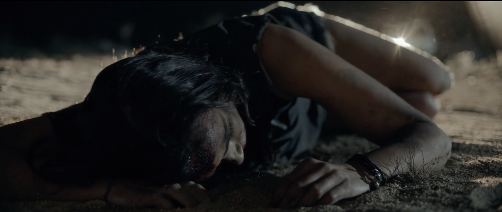 Bobbi lying face down in the road in Blood Star, playing dead, nearly identical framing to the cold-open victim