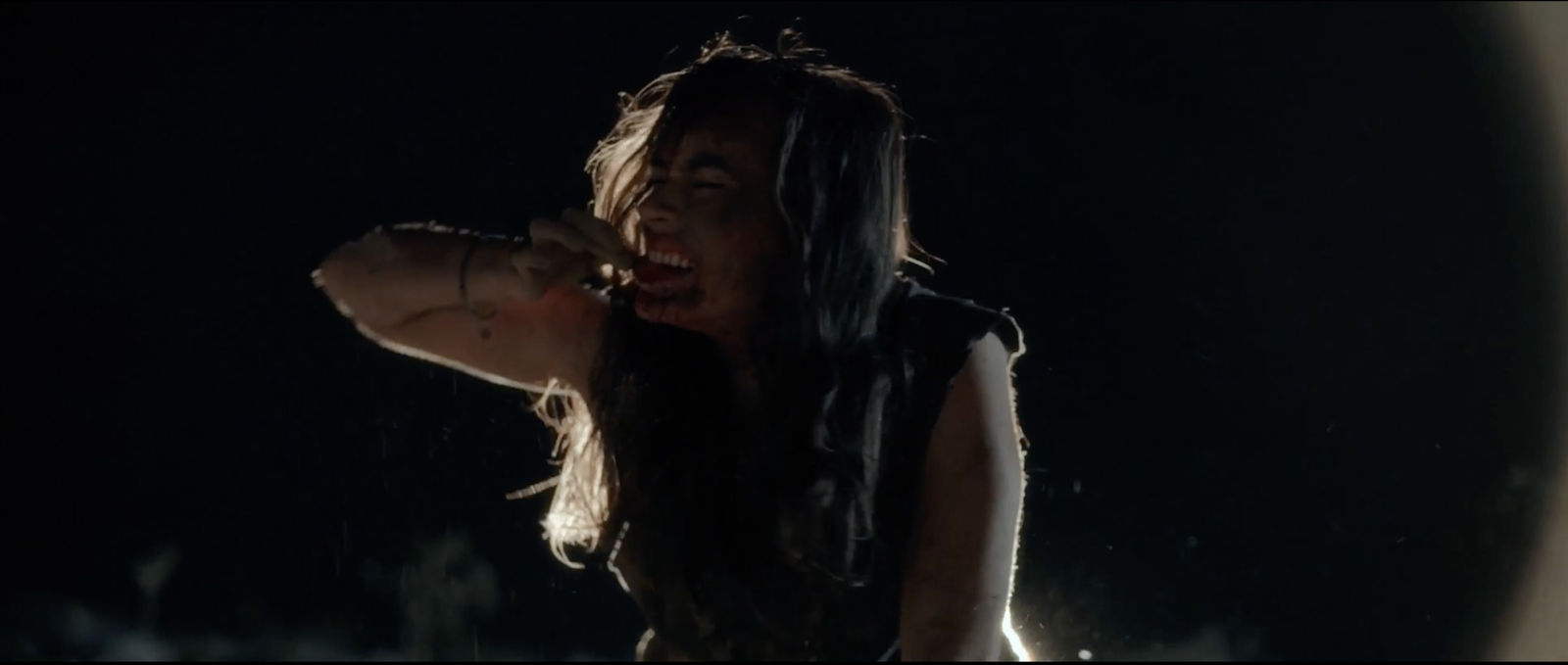 Close-up of a woman crying in the dark desert night, blood on her face