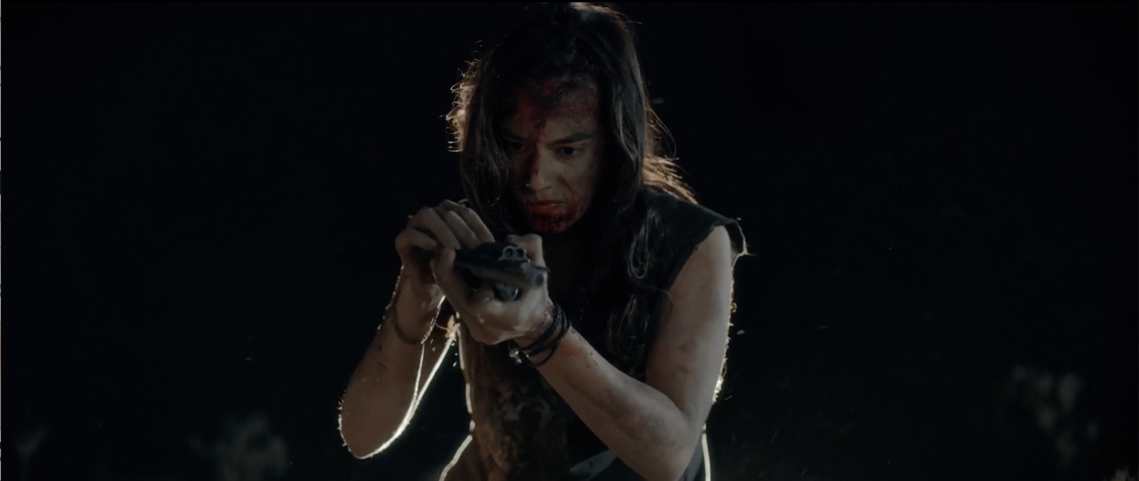 Bobbi examining Sheriff Bilstein's revolver with both hands, blood on her face