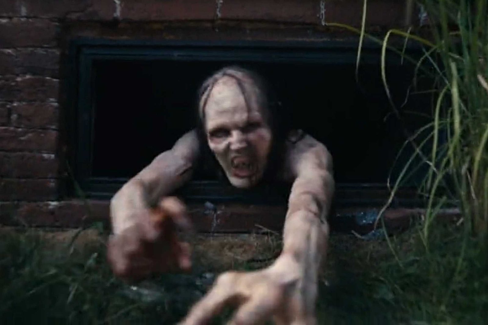 The Mother creature reaching out through a basement window in Barbarian