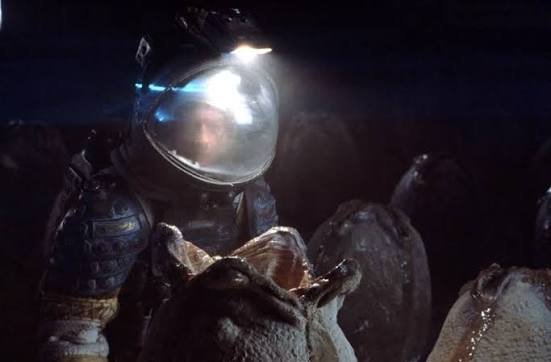 An astronaut's helmet light illuminating alien eggs in the derelict ship's silent egg chamber in Alien (1979)