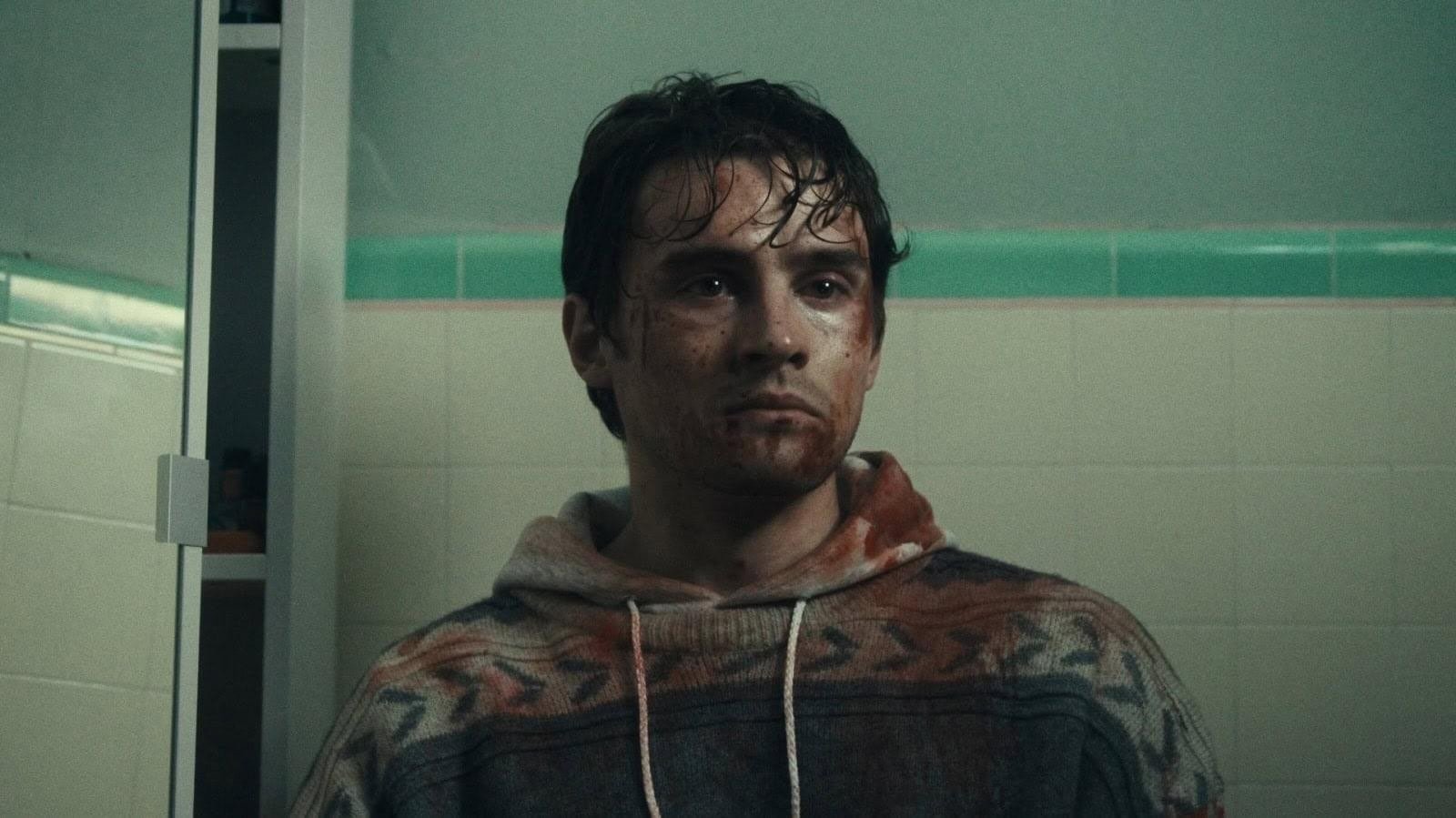 Bear, bloodied and shaken, standing in a bathroom in Obsession (2025)